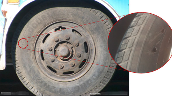 Picture zooming into a puncture on a tire